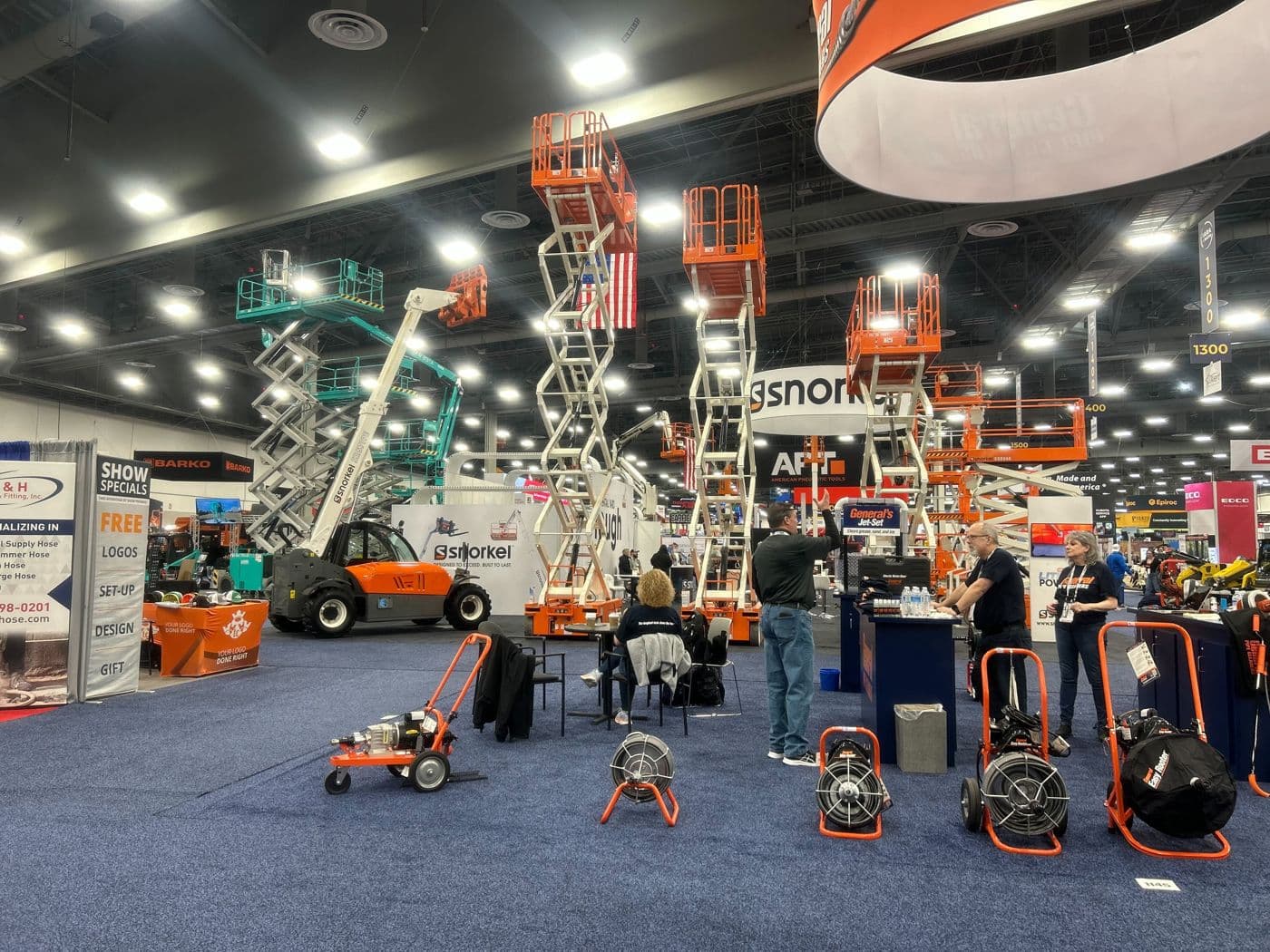 Scissor lifts, telehandlers and other rental equipment on an industry trade show floor