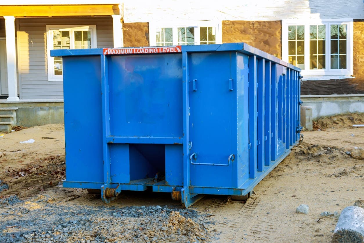 Roll away dumpter on housing development lot.