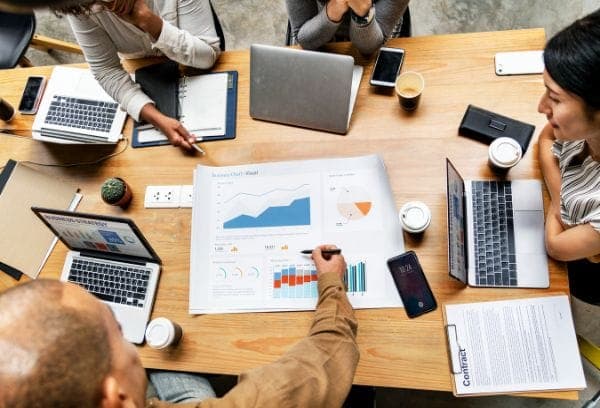 business team running through business plan over looking chart plan